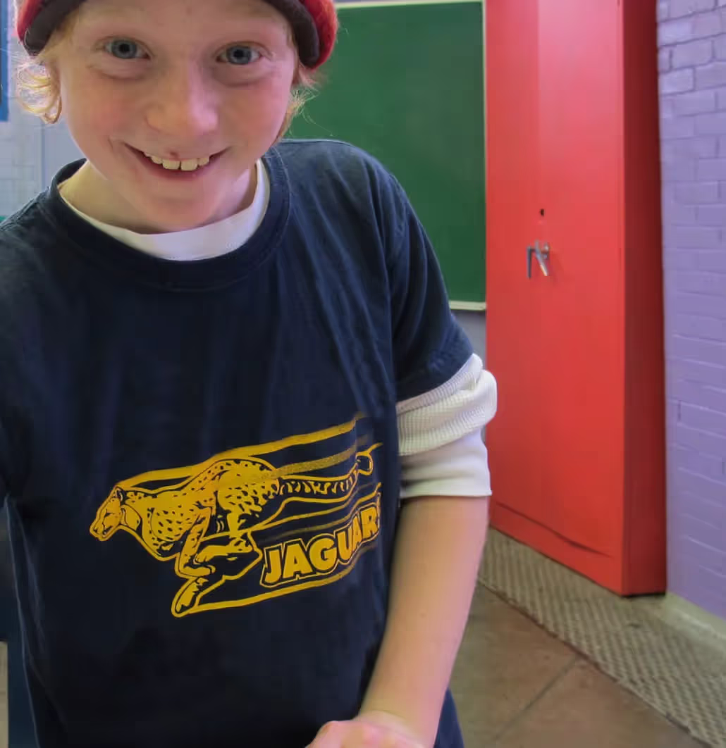 A young boy wearing a red hat and a blue shirt